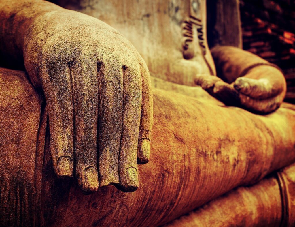 Photo of Buddha statue with close up detail of hands