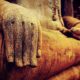Photo of Buddha statue with close up detail of hands